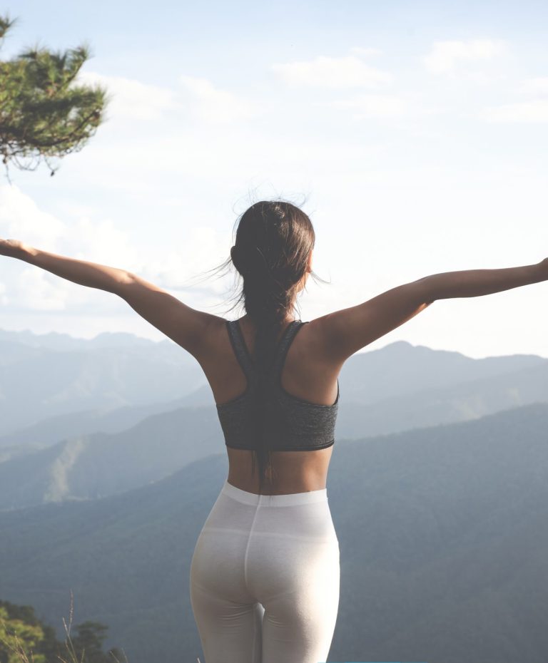 Beautiful young woman meditating and exercising on top of him.